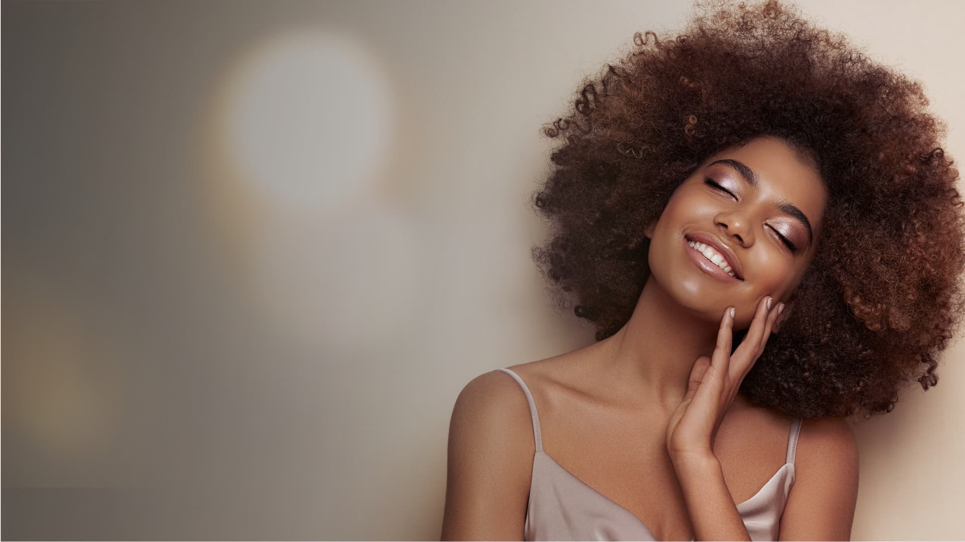 a woman with curly hair and eyes closed