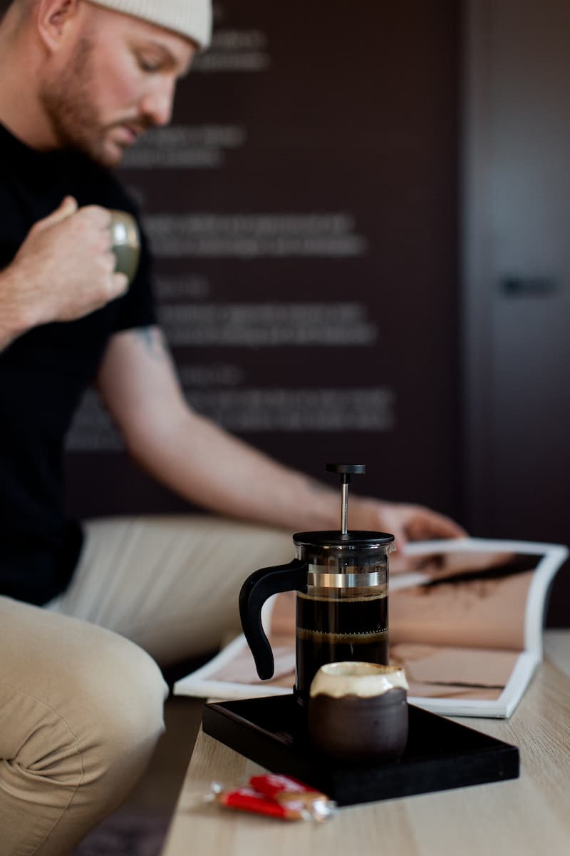 a person sitting on a couch with a coffee press