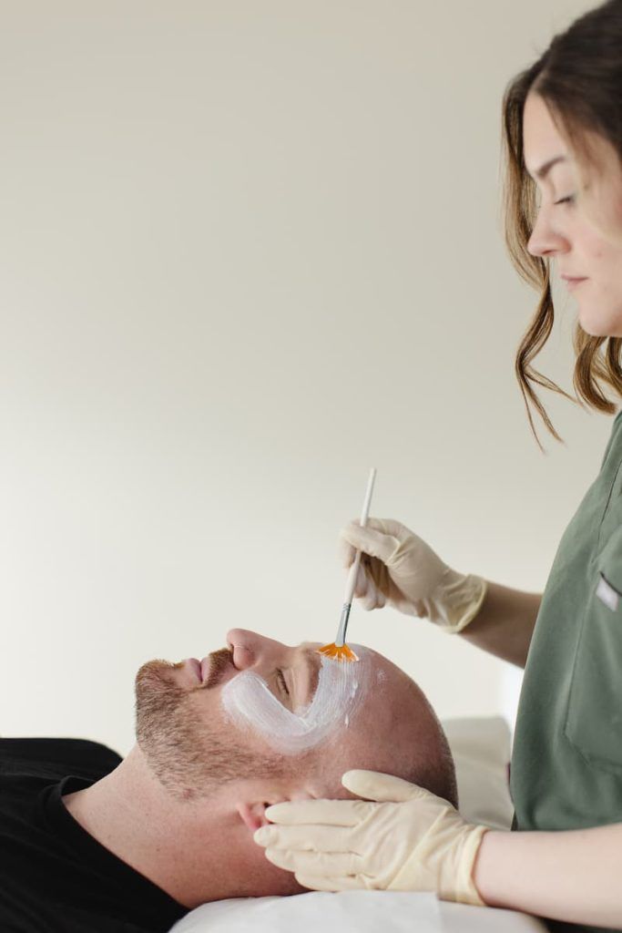 a man lying down with a brush on his face