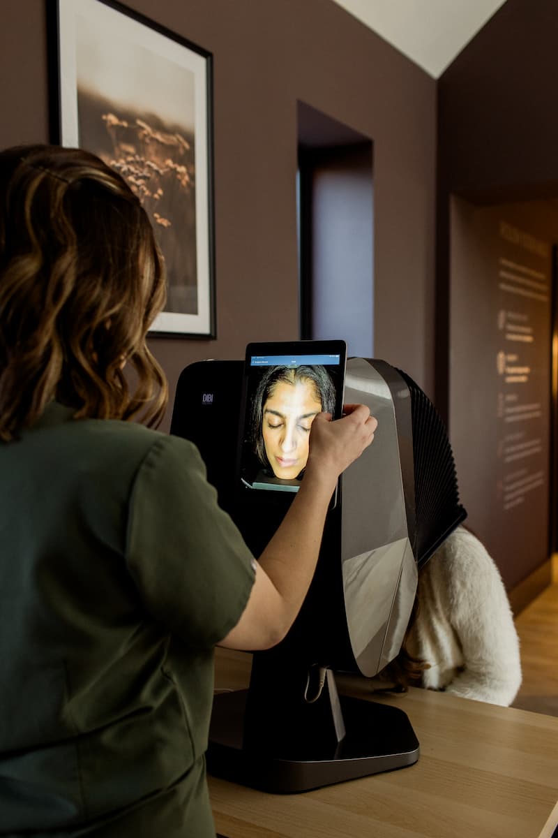 a woman using a tablet to take a picture of a woman's face