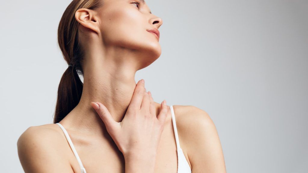 a woman with her hand on her neck