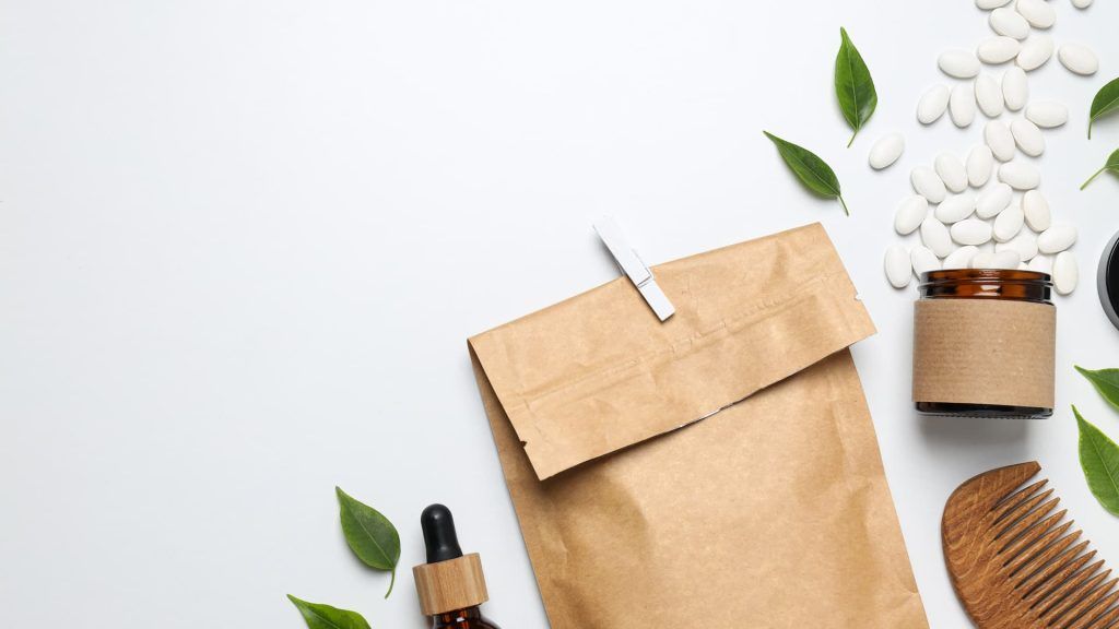 a brown paper bag with a dropper next to a brown paper bag with leaves